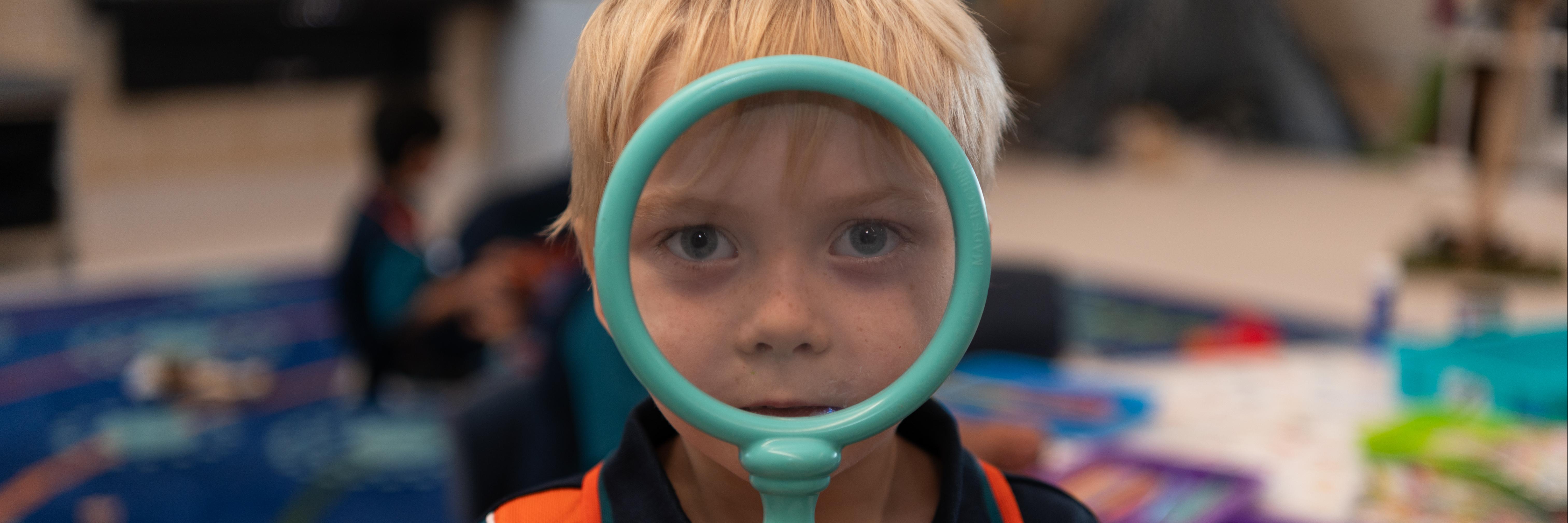Student with Magnifying Glass